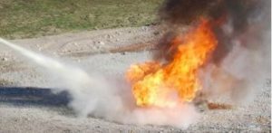 fire in street being put out with a fire extinguisher